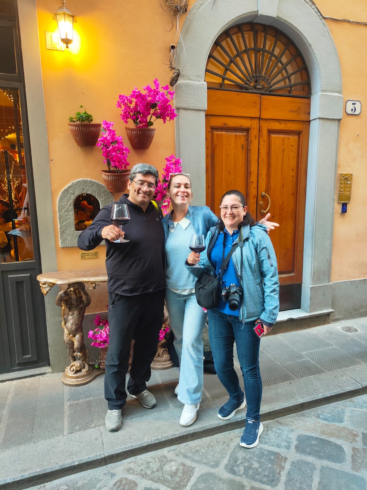 Guests toasting Tuscan red wine at a historic Florentine wine window (Buchetta del Vino)