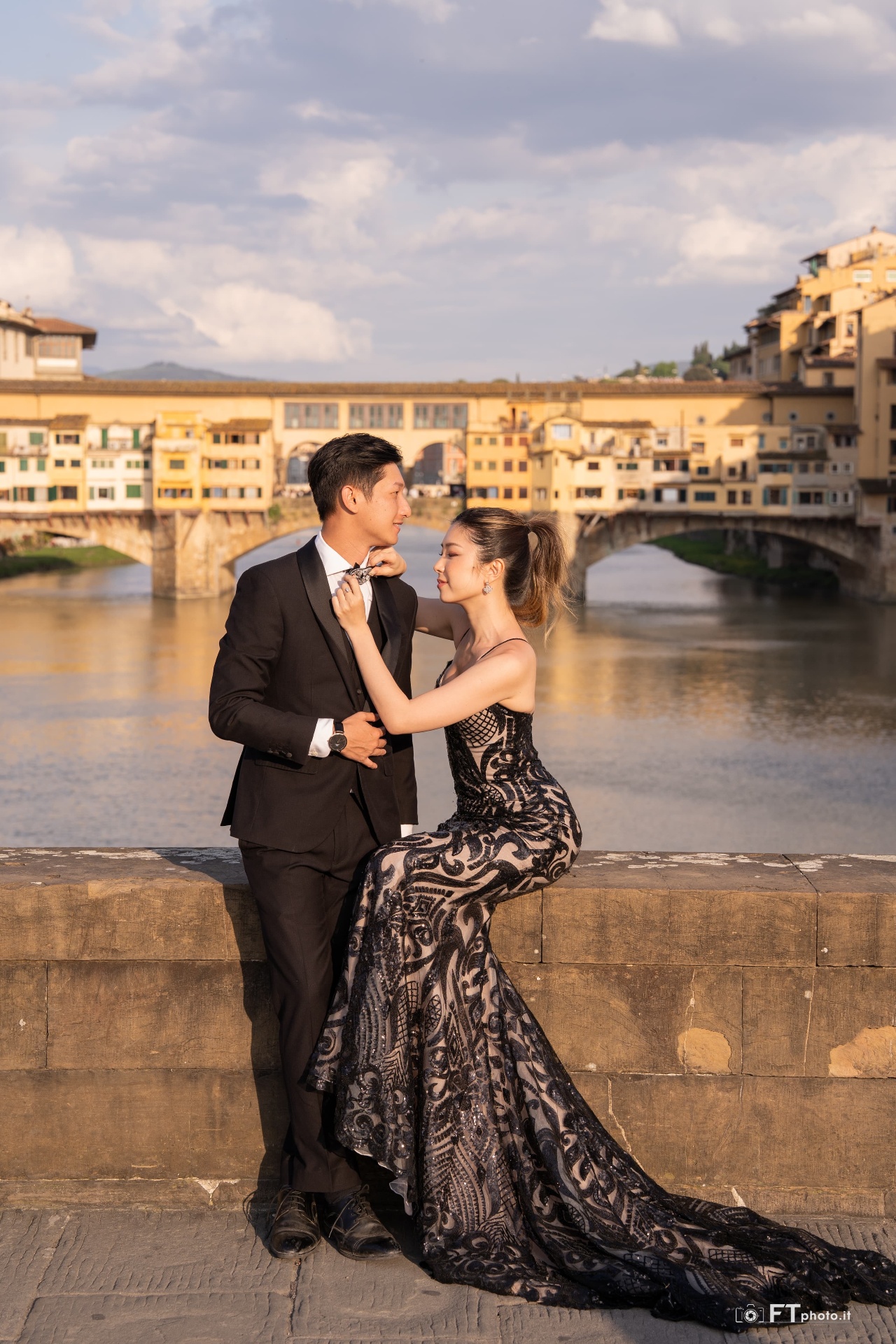 Couple posing in front of Ponte Vecchio in Florence